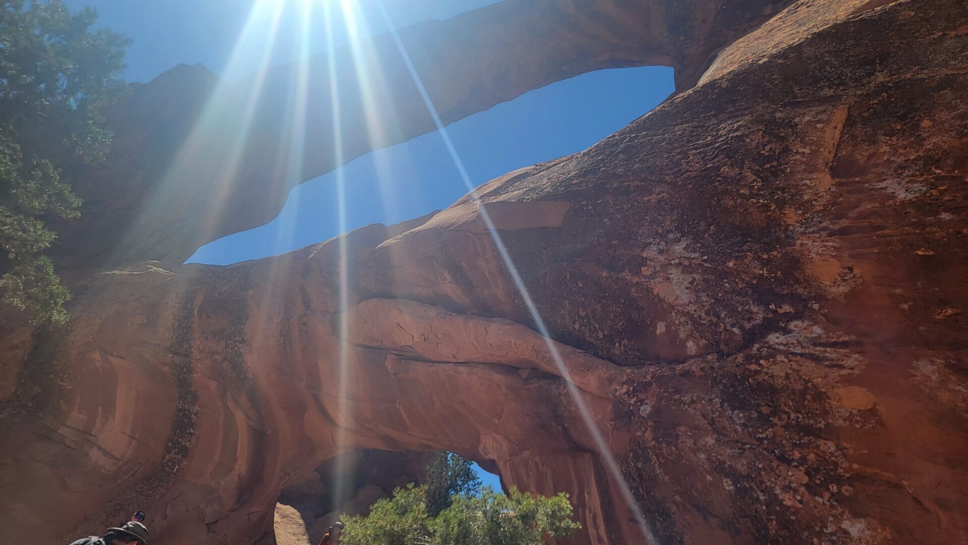 Sunbeams through red sandstone arch